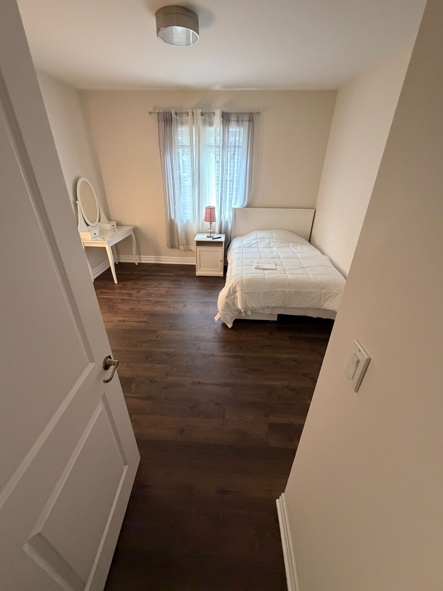 Guest bedroom with newly installed dark wood-look flooring
