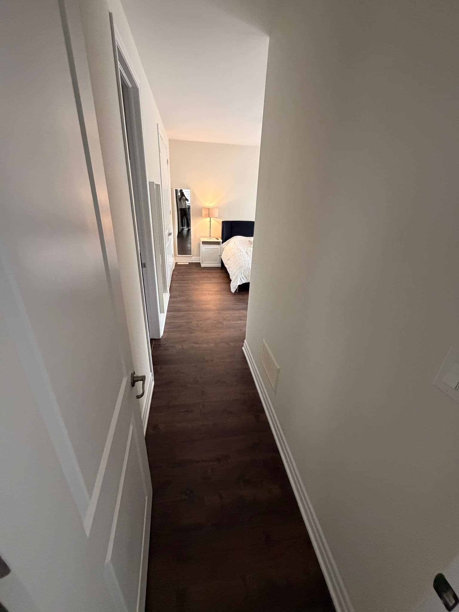Continuous dark plank flooring running down an upstairs hallway