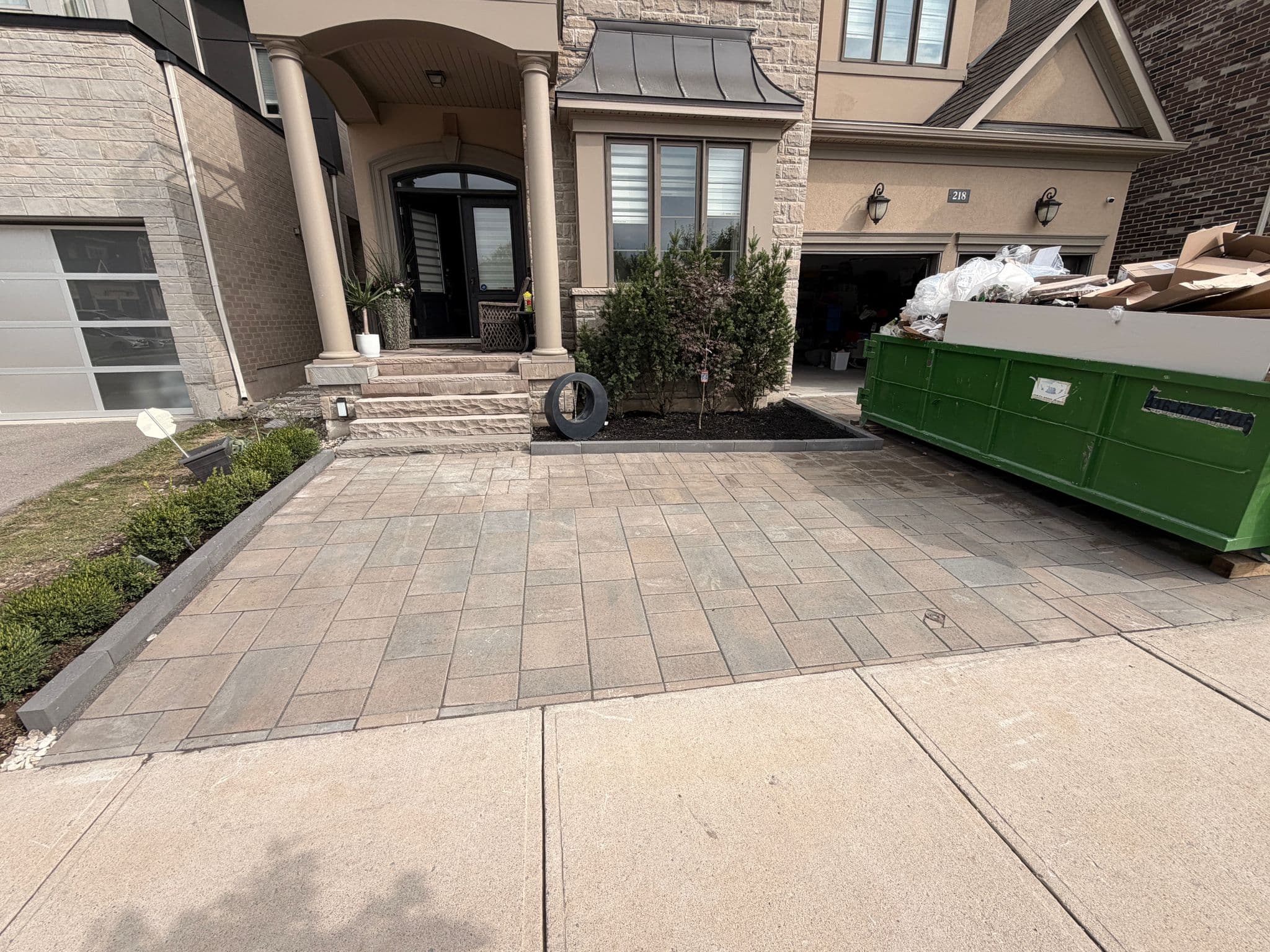 New interlock driveway and walkway in front of a stone house