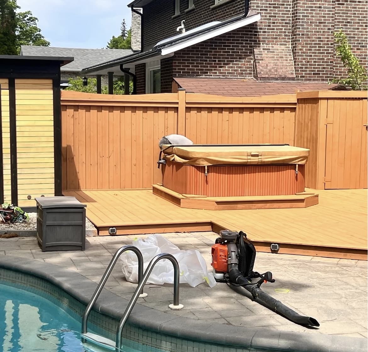 Backyard deck and cedar fence freshly stained around the hot tub